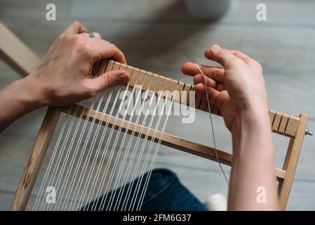 Mani di donna che preparano telaio per tessitura tappeto di lana Foto Stock