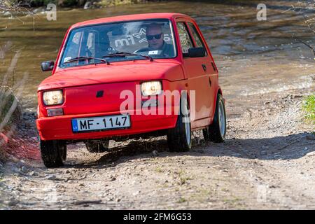 Madona, Lettonia - 01 maggio 2021: La Fiat 126, una vettura rossa a tempo indolo, supera l'ostacolo all'acqua Foto Stock