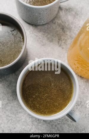 Struttura superficiale del brodo osseo in una tazza con un Vaso Mason palla Foto Stock