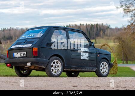 Madona, Lettonia - 01 maggio 2021: Colorata auto a noleggio PanCars Fiat 126 parcheggiata sul lato di una strada di campagna Foto Stock