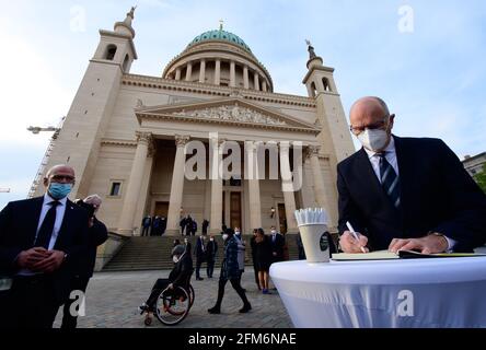 Potsdam, Germania. 06 maggio 2021. Dietmar Woidke (SPD), Ministro Presidente del Brandeburgo, firma il libro di condoglianze di fronte alla Chiesa Nikolai dopo il servizio commemorativo per i residenti uccisi dell'Oberlinhaus. Quattro corpi e una persona gravemente ferita sono stati trovati nella struttura di Oberlinhaus il 28. 04. 2021. Credit: Soeren Stache/dpa-Zentralbild/dpa/Alamy Live News Foto Stock