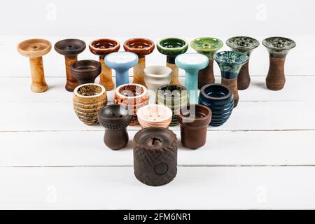 Ciotole di hookah su sfondo bianco di legno. Forme e colori diversi. Foto Stock