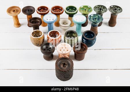 Ciotole di hookah su sfondo bianco di legno. Forme e colori diversi. Foto Stock