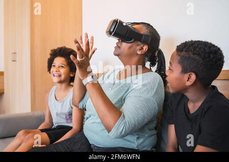 Nonna e nipoti che giocano insieme con occhiali VR. Foto Stock