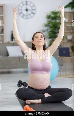 donna incinta sta sollevando le braccia Foto Stock