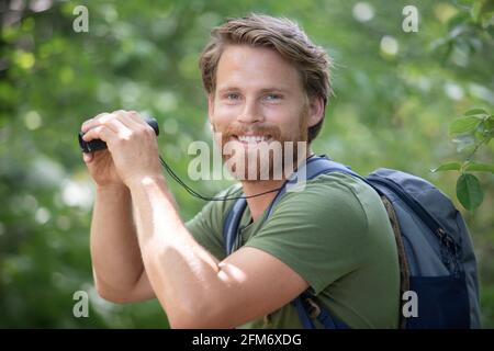 uomo di mezza età con un binocolo in natura Foto Stock