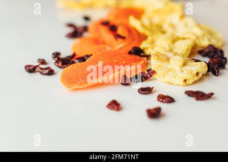 Mescolare frutta secca su sfondo chiaro. Ananas, mango e mirtillo. Cibo sano e snack. Foto Stock
