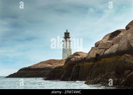 La torre faro Rustic Moose Peak si trova sulla cima di un'isola rocciosa mentre il sole splezza attraverso le nubi tempeste nel Maine orientale. Ci sono tour da portare a visitare Foto Stock