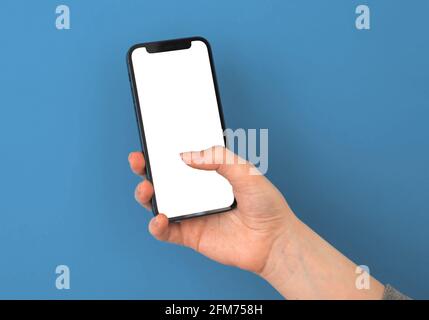 Kharkov, Ucraina - 5 maggio 2021: La mano della giovane signora tiene lo schermo mockup dello smartphone Apple su uno sfondo colorato Foto Stock