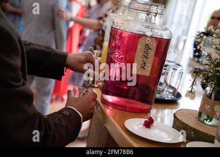 l'uomo versa una bevanda di succo di ribes nero da un recipiente da forno in un bar Foto Stock