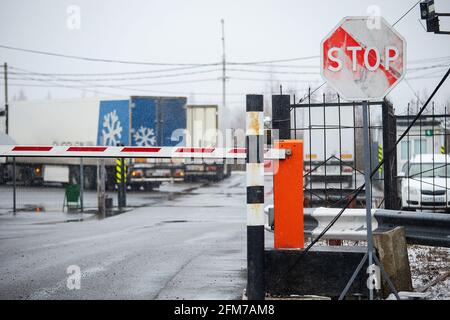 barriera abbassata all'ingresso della fabbrica. per un oggetto limitato è richiesto un passaggio. ingresso chiuso per il trasporto. magazzino in legno all'aperto. Foto Stock