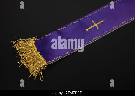 Viola viola stola del sacerdote con una croce su un nero sfondo Foto Stock