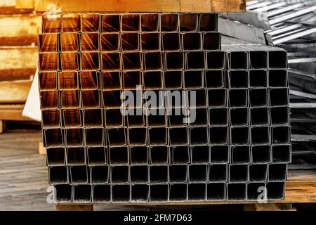 Un mucchio di piastre metalliche e tubi industriali quadrati di fondo struttura. Materiali da costruzione nel cantiere Foto Stock