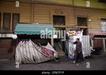 (210506) -- IL CAIRO, 6 maggio 2021 (Xinhua) -- UN uomo cammina oltre cabine chiuse in un mercato notturno al Cairo, Egitto, il 6 maggio 2021. Mercoledì il primo ministro egiziano Mostafa Madbouly ha annunciato nuove misure precauzionali della durata di due settimane per controllare la diffusione del COVID-19. Madbouly ha detto in una conferenza stampa televisiva che ristoranti, cinema, negozi, centri commerciali, club e strutture di intrattenimento saranno chiusi alle 21 ora locale (1900 GMT) per due settimane a partire dalla sera di giovedì, Poco prima della fine del mese santo islamico del Ramadan e la festa Eid al-Fit. (Xinhua/Ahmed Gomaa) Foto Stock