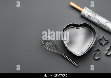 Set di utensili da cucina su sfondo scuro Foto Stock