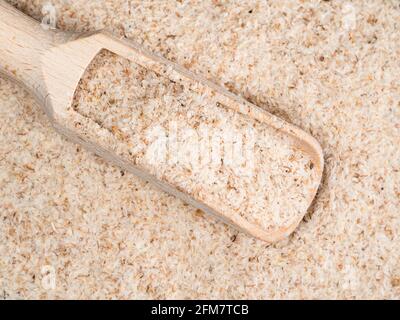 Vista dall'alto della paletta di legno nella chiocciatura di buccia di Psyllium Foto Stock