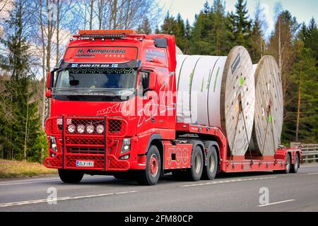 Red Volvo FH16 700 camion di Kuljetusliike H. Kumpusalo trasporta due grandi avvolgicavo in Prysmian su rimorchio a letto basso. Forssa, Finlandia. 29 aprile 2021. Foto Stock