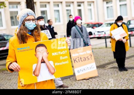 Hannover, Germania. 07 maggio 2021. Durante una manifestazione davanti al parlamento di Stato, un insegnante di asilo tiene manifesti con lo slogan 'il nuovo NKiTaG? Ti fa piangere!". Oggi, il comitato culturale del parlamento statale della bassa Sassonia sta discutendo una nuova legge sull'asilo. Credit: Moritz Frankenberg/dpa/Alamy Live News Foto Stock