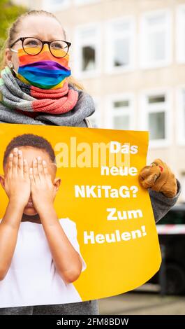 Hannover, Germania. 07 maggio 2021. Durante una manifestazione davanti al parlamento di Stato, un insegnante di asilo tiene manifesti con lo slogan 'il nuovo NKiTaG? Ti fa piangere!". Oggi, il comitato culturale del parlamento statale della bassa Sassonia sta discutendo una nuova legge sull'asilo. Credit: Moritz Frankenberg/dpa/Alamy Live News Foto Stock