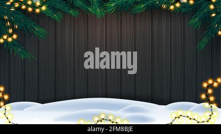 Sfondo di Natale, recinzione in legno di tavole con cornice di rami albero di Natale, ghirlanda di luci lampadina gialla e neve sul pavimento Foto Stock