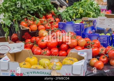 Verdure, pomodori rossi e gialli di fondo in un mercato di prodotti freschi a Londra. Foto Stock