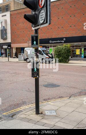 Attraversamento pedonale con uomo verde illuminato per consentire alle persone di Attraversate in modo sicuro una trafficata strada cittadina di Norwich Foto Stock