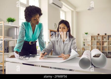 Due architetti creativi o interior designer che lavorano su un nuovo design nel loro ufficio Foto Stock