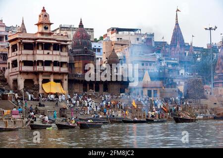 La cremazione indù Ghats sulle rive del fiume sacro Gange a Varanasi in India del nord. Foto Stock