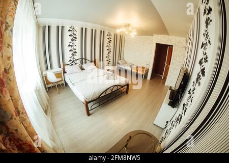 letto matrimoniale in appartamento. letto doppio accogliente. interni minimalistici in colori luminosi. biancheria da letto morbida e pulita in camera. letti Foto Stock