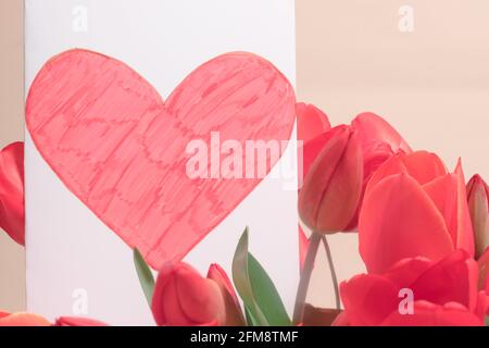 Bellissimo biglietto d'auguri con tulipani e cartolina cuore rosso con posto per testo copia passo. Per la festa del 14 febbraio, San Valentino, Madre D Foto Stock