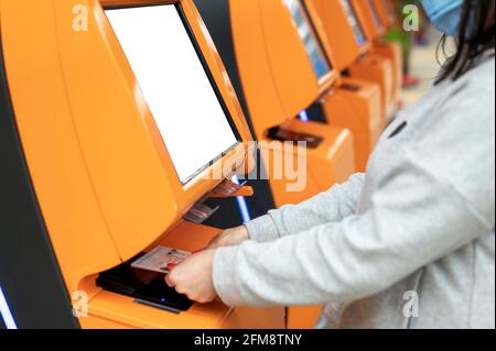 la donna scansiona il suo passaporto al banco della compagnia aerea per il check-in self-in all'aeroporto. la donna viaggia in aereo e fa il check-in self-service all'aeroporto usi Foto Stock