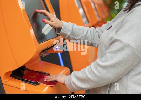 Viaggiatore che utilizza il servizio di check-in self-service presso l'aeroporto, primo piano punto dito sul display, domanda per confermare i dettagli della prenotazione del volo. Donna Foto Stock