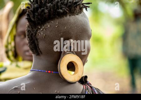 Alcuni dei membri maschi della tribù indossano i piatti nelle loro orecchie. DEBUB OMO ZONE, ETIOPIA: INCONTRA LA tribù dove le donne iniziano a stendere le labbra Foto Stock