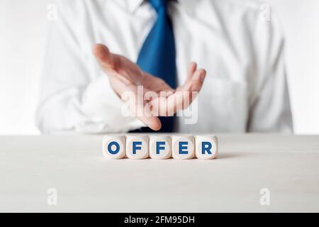 Mano di un uomo d'affari che presenta i cubetti di legno con la parola offerta. Concetto di offerta commerciale. Foto Stock