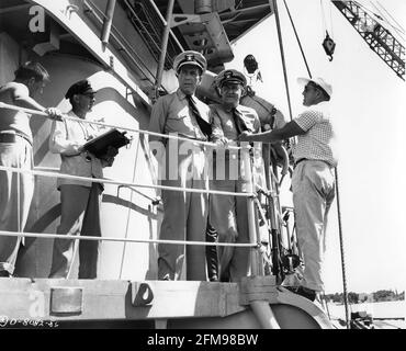 HUMPHREY BOGART come Capitano Queeg sulla posizione impostata candid con Regista EDWARD DMYTRYK e Movie Crew durante le riprese DEL CAINE MUTINY 1954 regista EDWARD DMYTRYK basato sul Pulitzer Romanzo vincitore di premi di Herman Wouk music Max Steiner produttore Stanley Kramer Columbia immagini Foto Stock