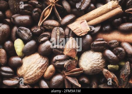 Primo piano immagine di chicchi di caffè, anice, bastone di cannella, cialde di cardamomo e noce moscata, fuoco selettivo. Foto Stock