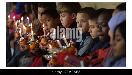 I bambini della St Barnaba Church of England School, Pimlico, si preparano a partecipare alle celebrazioni annuali di Christingle per i bambini della Childrens Societys presso l'abbazia di Westminster. Il tema di quest'anno è brillare una luce su BullyingLo arancione simboleggia il mondo, il nastro rosso il sangue di Cristo e la candela la luce del mondo. pic David Sandison 28/11/2002 Foto Stock