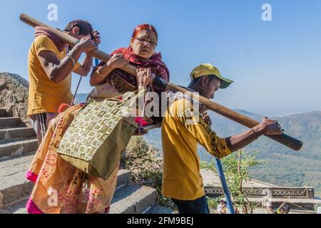JUNAGADH, INDIA - 10 FEBBRAIO 2017: Facchini che trasportano una persona sui gradini della collina di Girnar, stato del Gujarat, India Foto Stock