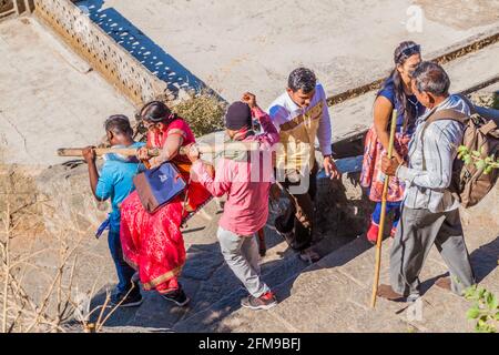 JUNAGADH, INDIA - 10 FEBBRAIO 2017: Facchini che trasportano una persona sui gradini della collina di Girnar, stato del Gujarat, India Foto Stock