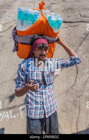 JUNAGADH, INDIA - 10 FEBBRAIO 2017: Portatore che trasporta le merci a Girnar Hill, Gujarat dichiara, India Foto Stock