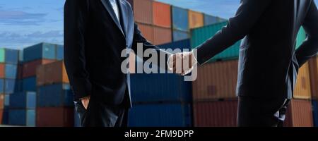 concetto commerciale di esportazione e importazione di merci. Primo piano mano di uomini d'affari che scuotono la mano al terminal dei container industriali. trasporto marittimo e logistica Foto Stock