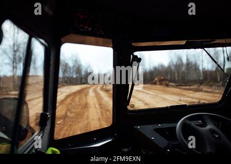 Vista dall'interno del SUV in fuoristrada. Viaggia attraverso i luoghi selvaggi in auto con traffico elevato. Vista dal sedile del passeggero al conducente Foto Stock