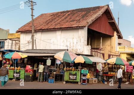 Mysore, Karnataka, India - Gennaio 2019: Negozi in un mercato affollato sotto i tetti inclinati di un vecchio edificio nella zona Chamundi Hills della città o Foto Stock