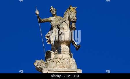 Italia, Sicilia, Sicilia sudorientale, angolo barocco, Ragusa, La luce del mattino, il Duomo di San Giorgio, la figura equestre barocca di San Giorgio con lancia, drago trafitto a lancia, ravvivare la figura del cavallo, la sporgenza del tetto meridionale, il cielo dell'agricoltore Foto Stock