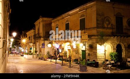 Italia, Sicilia, Sicilia sudorientale, angolo barocco, Ragusa, Ragusa di notte, centro città, corso XXV Aprile, lanterne, zona pedonale, esposizione prolungata, persone offuscate Foto Stock