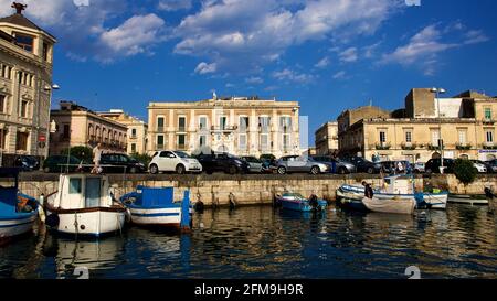 Italia, Sicilia, Siracusa, penisola di Ortigia, Isola di Ortigia, ponte per Ortigia, barche, automobili, edifici barocchi, cielo blu scuro con nuvole, Foto Stock