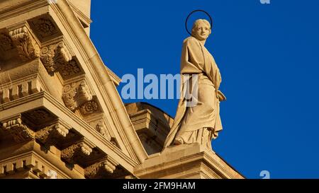 Italia, Sicilia, Siracusa, Penisola di Ortigia, Isola di Ortigia, Cattedrale di Siracusa, luce serale, santa figura sulla sporgenza del tetto, cielo blu Foto Stock