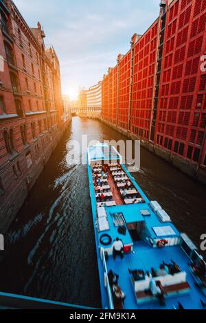 Crociera turistica di barca in stretto canale di famosi Speicherstadt warehouse district con red edifici in mattoni di Amburgo, Germania. Foto Stock