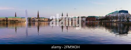 Bellissima vista panoramica del fiume Alster e dal municipio di Amburgo - Rathaus a molla a guadagnare sera durante l ora d'oro. Banner panoramica shot. Foto Stock