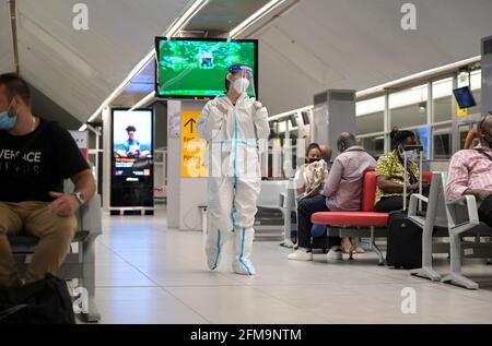 COSTA D'AVORIO, Abidjan, aeroporto, viaggiatore cinese con abbigliamento di protezione durante Corona Pandemic tempo al cancello sul volo per Parigi / ELFENBEINKÜSTE, Abidjan, Flughafen, Chinesische Reisende in Schutzkleidung während der Corona Pandemie Foto Stock